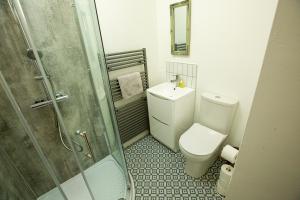 a small bathroom with a toilet and a shower at Arthur Street cottage in Hillsborough