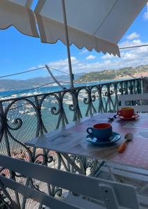 a table with a cup of coffee on a balcony at Appartamento con splendida vista - Lerici Centro in Lerici
