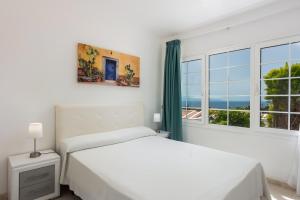 a white bedroom with a bed and a window at Haciendas IV in Adeje