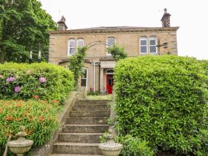 Una casa vieja con escaleras delante. en Libby's Place, en Keighley