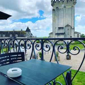 a table on a balcony with a clock tower at CHAMBRE BALCON in Pons