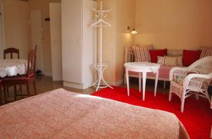 a room with a bed and a table and a couch at Tammiston Cottages in Naantali