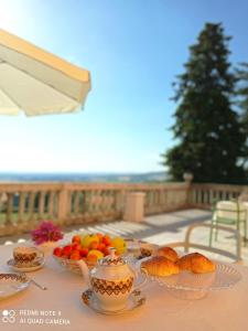 a table with cups and bowls of fruit and croissants at Villa La Palazzina in Agazzano