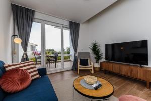 un soggiorno con divano blu e TV a schermo piatto di Apartment Maestral a Sutivan (San Giovanni di Brazza)