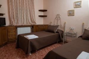a bedroom with two beds and a dresser at Casa Rural Doña Josefa in Cilanco +24 photos