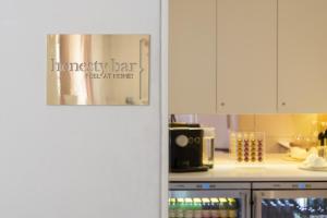 uma cozinha com armários brancos e uma placa que lê bar feliz real em casa em Eurostars Florence Boutique em Florença