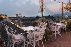 eine Gruppe von Tischen und Stühlen auf einer Terrasse in der Unterkunft Eurostars Florence Boutique in Florenz
