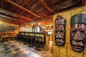 un restaurante con un bar con una máscara en la pared en Ezulwini Game Lodge en Hluhluwe