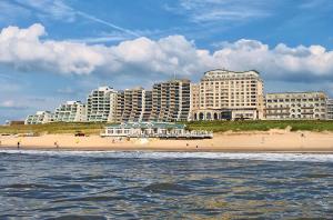 a beach in front of a city with tall buildings at Pura Vida Panorama in Oud-Ade
