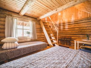 a bedroom with two beds in a log cabin at Metsaluige Turismitalu in Kabli +38 photos