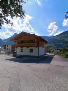 a house with a roof on the side of a road at Ferienhaus ANDREA in Ramsau im Zillertal