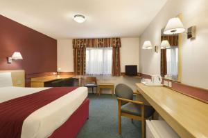 a hotel room with a bed and a desk at Days Inn Hotel Bradford - Leeds in Brighouse