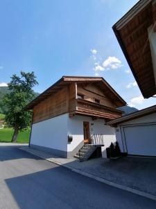 a house with a wooden roof and a garage at Ferienhaus ANDREA in Ramsau im Zillertal