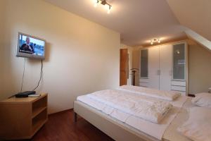 - une chambre avec un lit et une télévision murale dans l'établissement DHH Wald, à Kellenhusen