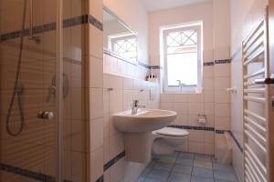 une salle de bain avec un lavabo, des toilettes et une douche dans l'établissement DHH Wald, à Kellenhusen 4 autres photos