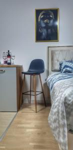 1 dormitorio con silla junto a la cama en Identity By Nights & Smiles, en Tuzla