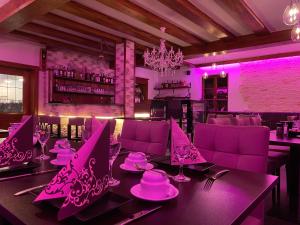 a dining room with a table and purple lighting at Hotel Wilder Mann in Feuchtwangen