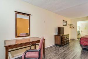 a room with a desk and a bed and a mirror at Econo Lodge At Six Flags in Austell +6 photos