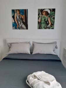 1 dormitorio con 1 cama con 2 cuadros en la pared en Scicli Suites, en Scicli