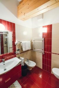 a bathroom with a white sink and a toilet at Hotel Bel Soggiorno in Malosco