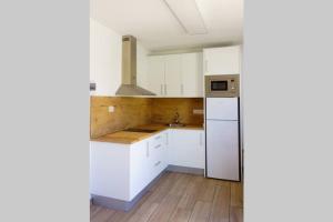 a kitchen with white cabinets and a sink at Apartamento recien reformado en centro a tres minutos de la playa in Corralejo