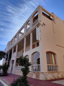 un gran edificio blanco con balcón en Hostal Las Dunas en El Cabo de Gata