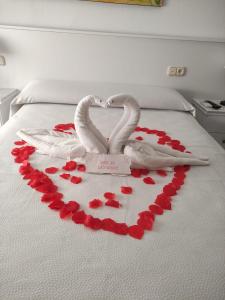 Dos cisnes forman un corazón en una cama en Hostal Las Dunas, en Cabo de Gata