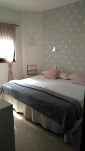 a bedroom with a large bed with pink pillows at CASA CAXOTA: Planta baja con terraza y vistas al mar in Fisterra