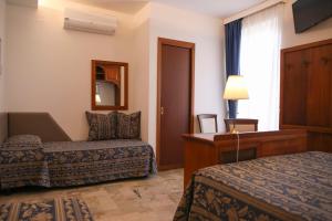 Pokój hotelowy z 2 łóżkami i biurkiem w obiekcie Hotel La Giara w Cefalù