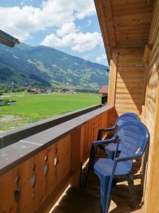 a balcony with a blue chair and a view of a field at Ferienhaus ANDREA in Ramsau im Zillertal