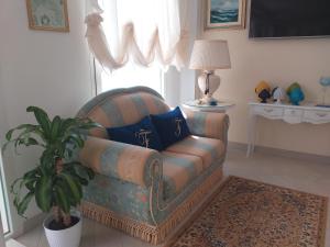 a living room with a couch and a potted plant at Falli Exclusive Rooms and Breakfast in Porto Cesareo