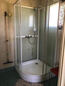 um chuveiro com uma caixa de vidro na casa de banho em Bogstrand, Dverbergveien 11, 8485 Dverberg em Dverberg
