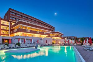 a hotel with a swimming pool in front of a building at Hotel Albatros Plava Laguna in Poreč