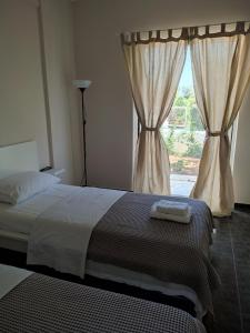 a bedroom with a bed and a window with curtains at Double M near Athens Airport in Markopoulo +40 photos