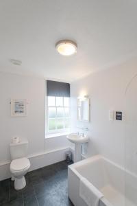 La salle de bains blanche est pourvue de toilettes et d'un lavabo. dans l'établissement Tregenna Castle Resort, à St Ives
