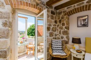 een kamer met een balkon met een tafel en stoelen bij Villa Monte Santo in Dubrovnik