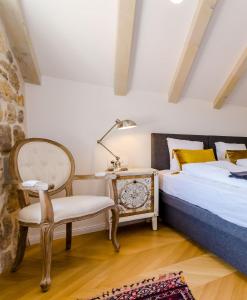een slaapkamer met een bed, een stoel en een lamp bij Villa Monte Santo in Dubrovnik
