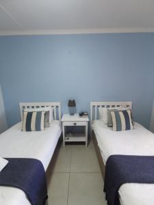 dos camas sentadas una al lado de la otra en una habitación en The Birdhouse Bed & Breakfast #NO Loadshedding #Solar Energy, en Gonubie