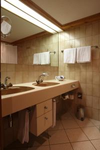 y baño con lavabo, espejo y toallas. en Residenz by Meierhof, en Davos
