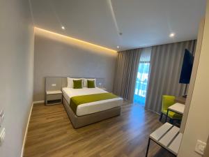 ein Hotelzimmer mit Bett und Schreibtisch in der Unterkunft Hotel Rhodos in Eforie Nord
