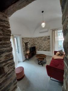 a living room with a couch and a stone wall at Casa Pernice in Penta-di-Casinca