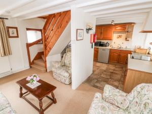 a living room with a table and a kitchen at Stable Cottage in Haverfordwest