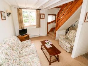 uma sala de estar com um sofá e uma mesa em Stable Cottage em Haverfordwest
