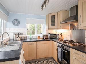 cocina con armarios de madera y horno con fogones en Stanegarth, en Keswick