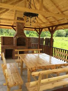 a wooden picnic table in a pavilion with a fireplace at Vila Maria in Buzau