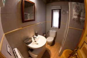 a bathroom with a sink and a toilet and a mirror at CASA DE PIEDRA in Casas del Monte +2 photos