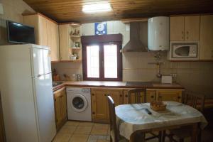 uma cozinha com uma mesa e um frigorífico branco em CASA DE PIEDRA em Casas del Monte