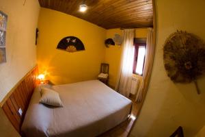 um quarto com uma cama branca numa parede amarela em CASA DE PIEDRA em Casas del Monte