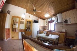 uma cozinha com uma mesa e um frigorífico branco em CASA DE PIEDRA em Casas del Monte