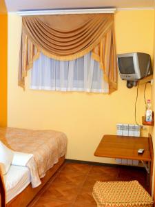 um quarto com uma cama, uma televisão e uma mesa em ВІКОНТ em Chishki